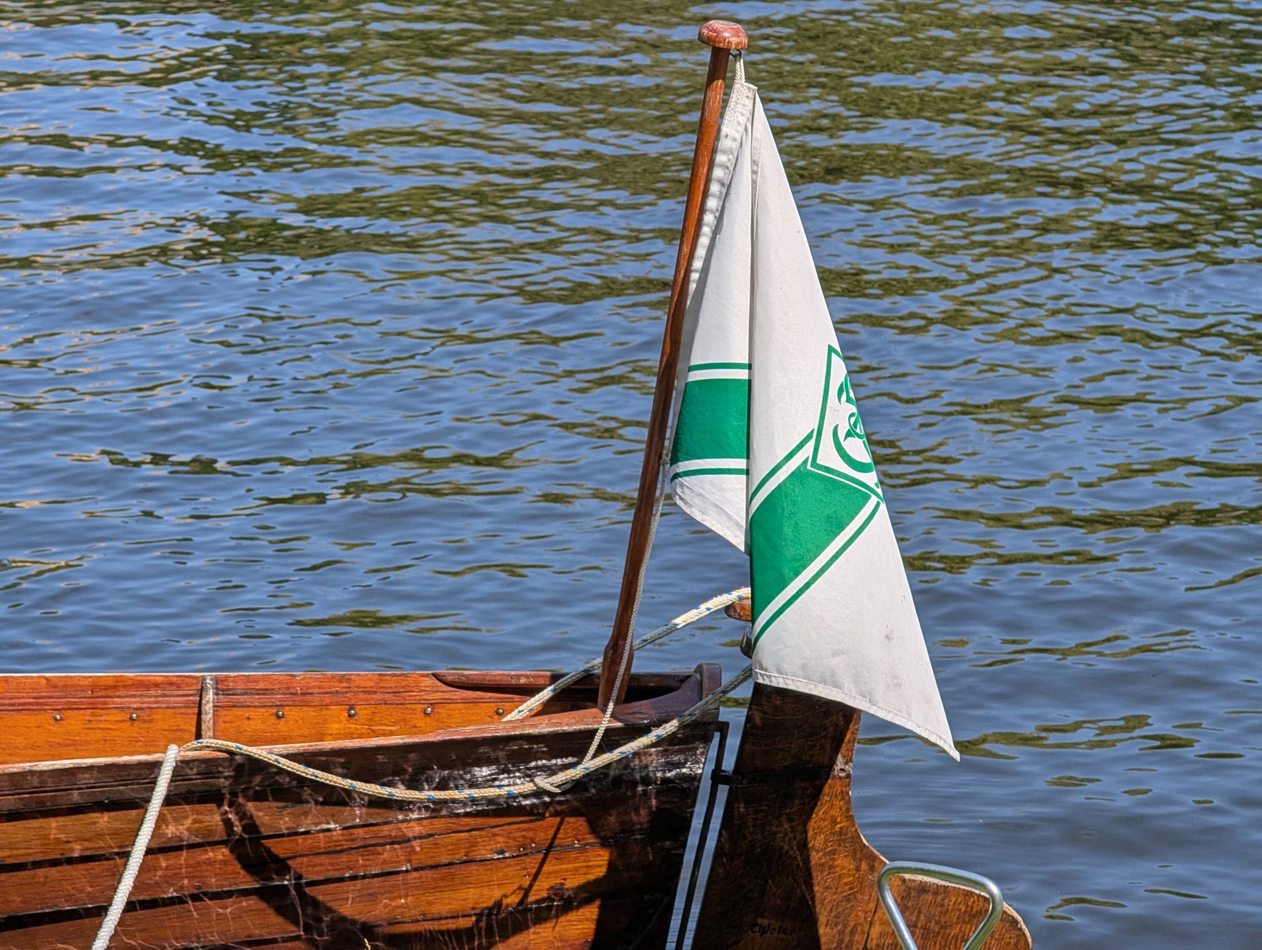 Das Heck eines hölzernen Gig-Vierers mit der grünweißen Flagge des Ruderclubs Königs Wusterhausen