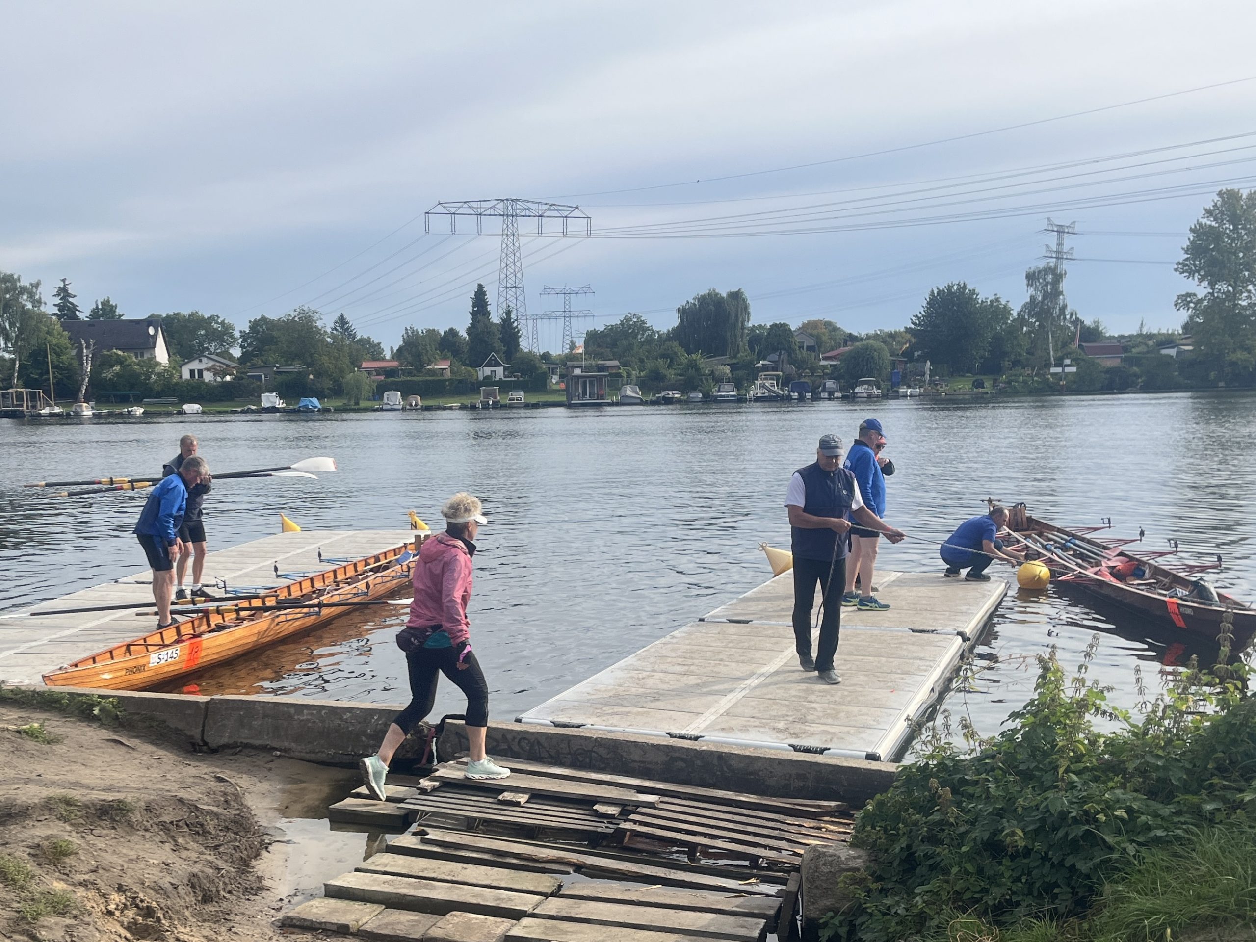 Zwei Gig-Vierer werden an Behelfsstegen ins Wasser gelassen