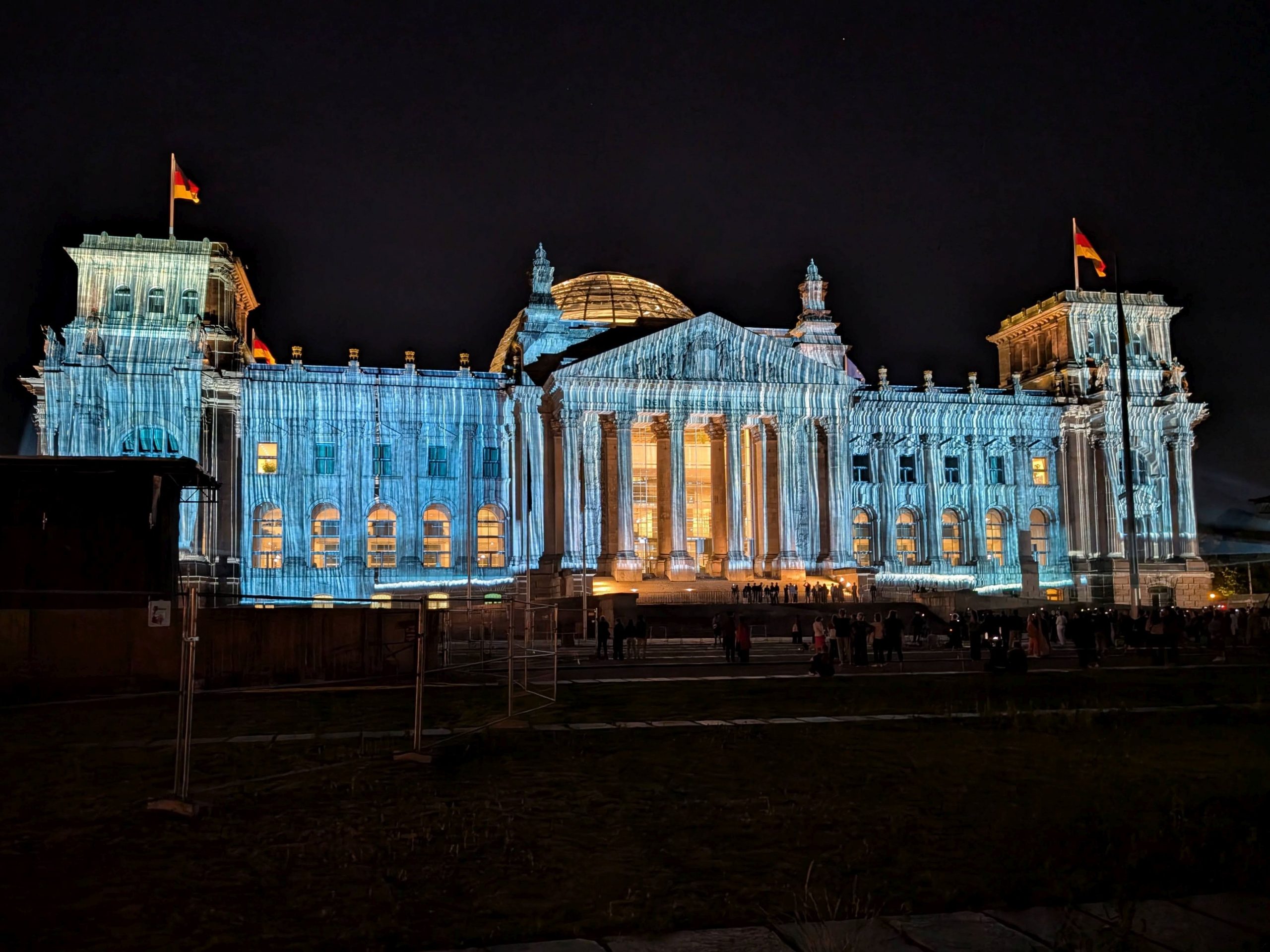 Der Reichstag bei Nacht. Die Fassade wird so illuminiert, dass der Eindruck von Verhüllung entsteht