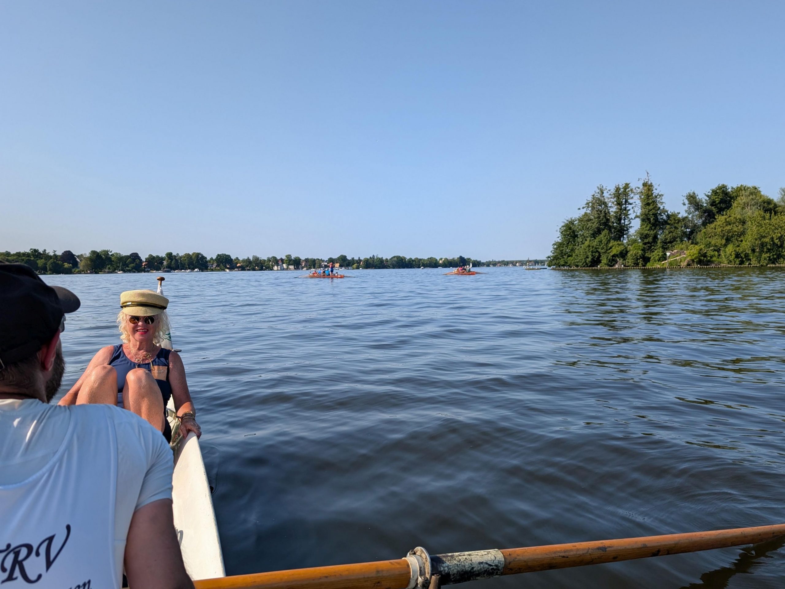 Der Zeuthener See (Dahme), im Vordergrund ein Ruderer der zur Steuerfrau schaut, die eine Kapitänsmütze trägt